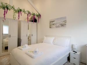 een slaapkamer met een wit bed en handdoeken bij Pass the Keys Modern Coastal Cottage in North Shields