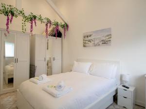 a bedroom with a white bed with towels on it at Pass the Keys Modern Coastal Cottage in North Shields