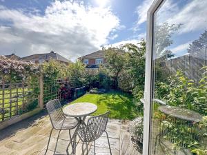 een patio met een tafel en stoelen en een tuin bij Pass the Keys Modern Coastal Cottage in North Shields