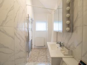 a white bathroom with a sink and a mirror at Pass the Keys Modern Coastal Cottage in North Shields +20 photos