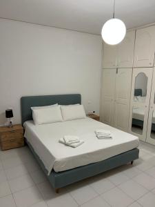 - une chambre avec un grand lit et un couvre-lit blanc dans l'établissement Johannes House, à Afantou