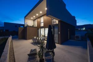 a house with a patio with a table and a umbrella at Luxury Villa Bueno in Kaštela