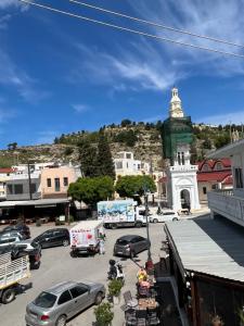 a town with cars parked in a parking lot with a clock tower at Johannes House in Afantou