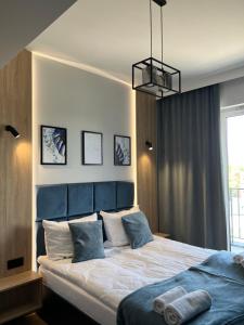 sypialnia z dużym łóżkiem z niebieskim zagłówkiem w obiekcie Apartament No 61 Blue Holiday Home Zator w Zatorze +34 zdjęcia