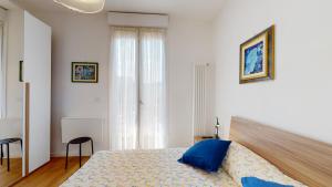 a bedroom with a bed with blue pillows on it at Avantgard Rooms S. Orsola in Bologna