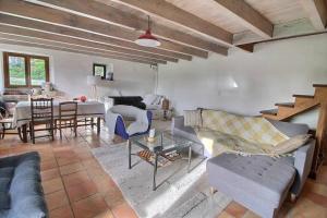 a living room with several couches and a table at Maison en pierre dans le Sidobre in Le Bez