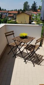 een houten tafel en 2 stoelen op een balkon bij La Regina in Vigevano