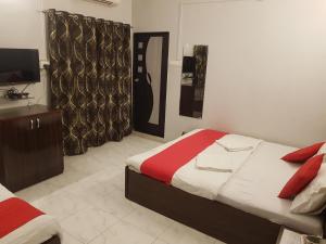a bedroom with a bed and a television in it at Hotel Trisha Residency in Lonavala
