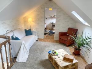 La Basse Cour في Tanlay: غرفة معيشة مع أريكة بيضاء وكرسي