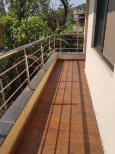 Un balcón de una casa con una pasarela de madera en Hotel Trisha Residency, en Lonavala