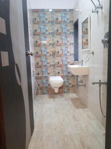 uma casa de banho com um WC, um lavatório e um espelho. em Hotel Trisha Residency em Lonavala