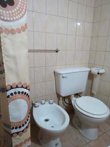 a bathroom with a toilet and a sink at Cabañas Troncos Del Salto in Potrerillos