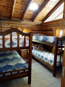 a room with three bunk beds in a cabin at Cabañas Troncos Del Salto in Potrerillos