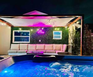 een woonkamer met een bank naast een zwembad bij Miami Chic 6BR Jacuzzi Games, 16 Min to Airport L52 in Tamiami