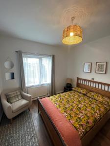 a bedroom with a bed and a chair and a window at Inviting & Spacious 3BD Flat - Shadwell in London
