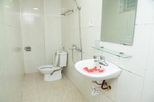 een witte badkamer met een wastafel en een toilet bij HOTTEL PHƯƠNG ĐÔNG in Hanoi