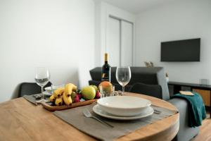 a table with a plate of fruit and wine glasses at Gold Apartment Ferrel I in Ferrel