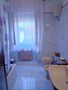 a bathroom with a toilet and a sink and a window at Tuscany Break in Gallicano