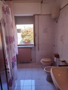 ein Bad mit einem WC, einem Waschbecken und einem Fenster in der Unterkunft Tuscany Break in Gallicano