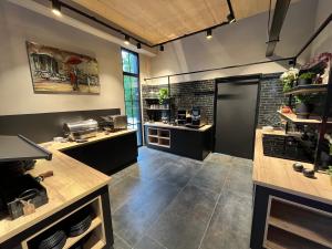 a large kitchen with black counters and a large window at Ferienbahnhof Reichenbach in Dahn