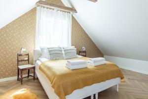 una camera da letto con un letto con lenzuola bianche e una finestra di Alice Backyard-Holiday home and Spa a Pärnu