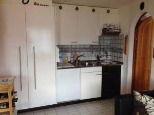 una cocina con armarios blancos y fregadero en 2-Zimmer-Wohnung Deheimu mit fantastischer Aussicht en Eischoll