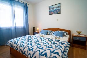 1 dormitorio con 1 cama con edredón azul y blanco en Sunny, en Vela Luka