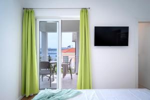 a bedroom with green curtains and a room with a table at Feelhvar along BlueLagoon beach in Hvar