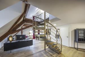 ein Wohnzimmer mit einer Wendeltreppe im Loft in der Unterkunft Kreuzstein Boutique-Apartment Hotel in Bayreuth