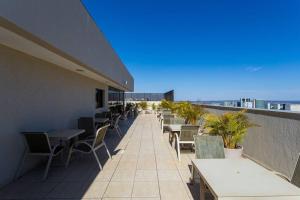 a row of tables and chairs on the roof of a building at Flat Hotel Nobile A18 in Brasilia