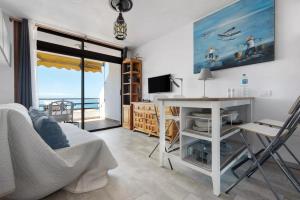 een woonkamer met een tafel en een bureau met uitzicht bij Apartment La Luna in Puerto de Santiago