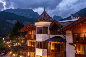 a building in a town with mountains in the background at Hotel Du Lac in Molveno