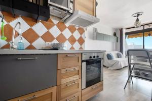 una cucina con piano cottura forno di livello superiore accanto a un soggiorno di Apartment La Luna a Puerto de Santiago