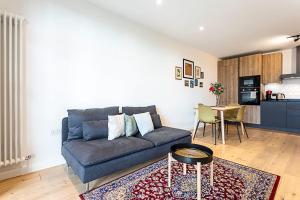 a living room with a couch and a table at Spacious Modern Hackney Flat in London