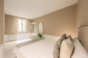 a bedroom with a large white bed and a window at AP Embajadores XV in Madrid