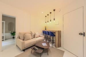 ein Wohnzimmer mit einem Sofa und einem Tisch in der Unterkunft AP Embajadores XV in Madrid