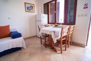 a dining room with a table and chairs and a couch at Sunny in Vela Luka