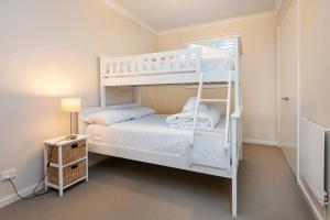 a bedroom with two bunk beds and a lamp at Whatmans Beach House - on the water's edge in Dunsborough