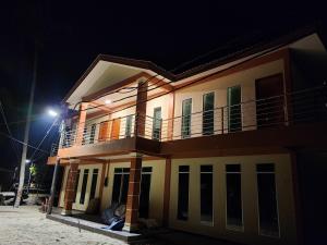 una casa con balcón por la noche en Juara Mutiara Resort en Tioman Island