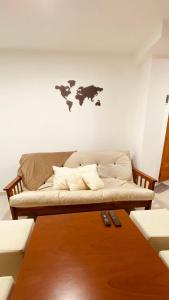 un sofá en una habitación con un mapa en la pared en Tierra en Ushuaia