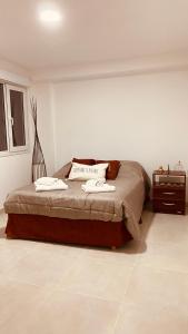 1 dormitorio con 1 cama con 2 toallas en Tierra en Ushuaia