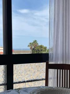 a bedroom with a view of the beach from a window at Sun, Sea, Beach Costa Calida Spain Henrys Apartment in Águilas