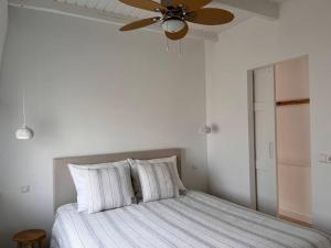- une chambre avec un lit et un ventilateur de plafond dans l'établissement Little Loft, Summerhouse near the beach, à Noordwijk aan Zee