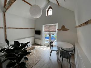 ein Esszimmer mit einem Tisch und einer Topfpflanze in der Unterkunft Little Loft, Summerhouse near the beach in Noordwijk aan Zee