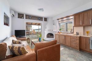 a living room with a couch and a kitchen at Arel luxury house in Kithnos