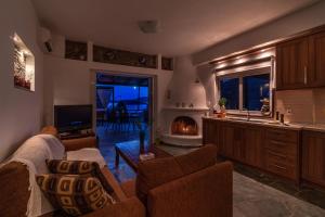 a living room with a couch and a fireplace at Arel luxury house in Kithnos