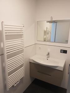 een witte badkamer met een wastafel en een spiegel bij Joanna Apartment- MA City 1 in Mannheim