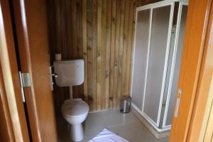 a bathroom with a toilet and a wooden wall at Tree Houses Hotel in Fethiye