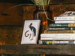 een vaas met een vogel op een stapel boeken bij Nightingale 