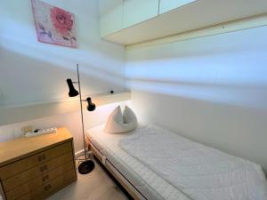 - une petite chambre avec un lit et une lampe dans l'établissement Ferienpark Sierksdorf App 53 - Strandlage, à Sierksdorf